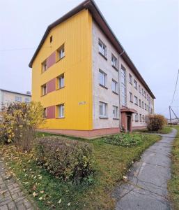 a yellow building on the side of a street at Quiet and comfortable apartment in Rakvere