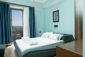 une chambre avec un grand lit blanc avec une fenêtre dans l'établissement Central Yerevan 2-Bedroom Flat With Balcony, à Erevan