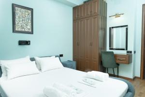 une chambre avec deux lits, un bureau et une chaise dans l'établissement Central Yerevan 2-Bedroom Flat With Balcony, à Erevan
