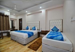 a bedroom with two beds with blue pillows at Family Hotel Euro Inn Highly Recommending in New Delhi