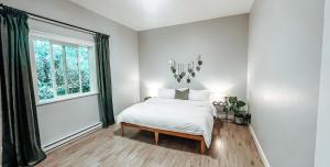 a white bedroom with a bed and a window at Sooke Getaway - Relax & Recharge in Nature, Private 7min to Sooke in Sooke