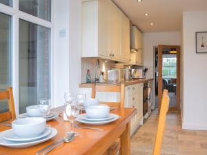 a kitchen with a wooden table with plates and wine glasses at Riverview Cottage in Acton