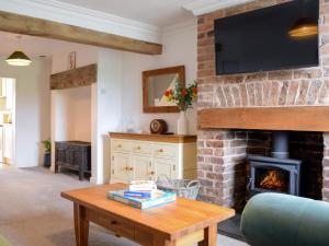 a living room with a fireplace with a tv on the wall at Riverview Cottage in Acton