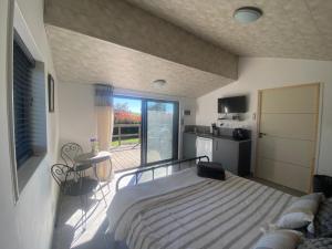 a bedroom with a bed and a kitchen with a balcony at Chalet Olisios, priate accommodation in beautiful countryside location in Pampelonne