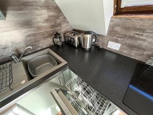 a kitchen counter with a sink and a dishwasher at Sconser - Uk50491 in Kylestrome
