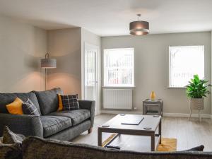 a living room with a couch and a table at Crofthouse - Uk43405 in Wigtown