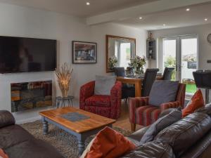 a living room with a couch and chairs and a table at Mountain View in Morfa Bychan