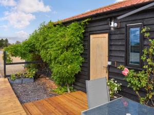 a house with a wooden deck with a door at Saddlers - Uk50519 in Ovington