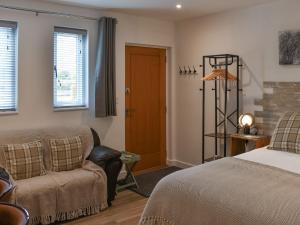 a bedroom with a bed and a chair and a door at Saddlers - Uk50519 in Ovington +2 photos