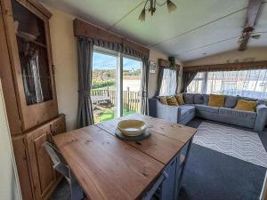 un salon avec une table et un canapé dans l'établissement Great Dog Friendly Caravan For Hire At North Denes In Suffolk Ref 40068Nd, à Lowestoft