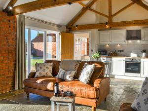 a living room with a brown couch in a kitchen at The Foldyard - Uk46004 in Rotsea