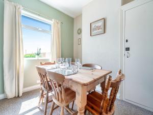 Un comedor con mesa y sillas y una ventana. en Home Bay, en Flamborough
