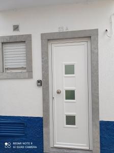 a white door on the side of a building at A Casinha in Nazaré