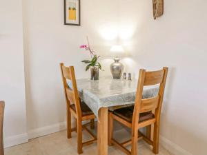 a dining room table with chairs and a vase with flowers at Sealladh Apartment - Ukc6792 in Port Appin