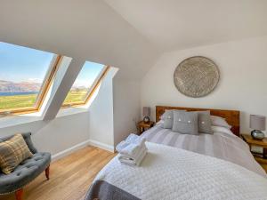 a bedroom with a bed and a chair and windows at Sealladh Apartment - Ukc6792 in Port Appin