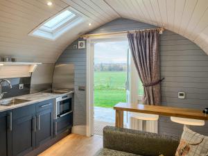 a kitchen with blue cabinets and a table and a window at Uuu Pod-Uk45325 in Forfar