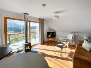 a living room with a couch and a fireplace with a view at Torrin - Uk50497 in Kylestrome