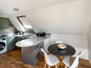 a kitchen with a small table and white chairs at Torrin - Uk50497 in Kylestrome