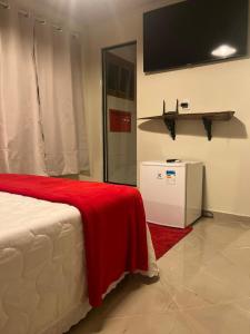 a bedroom with a bed with a red blanket on it at Sítio Do Manacá in Domingos Martins