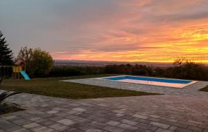a swimming pool with a sunset in the background at Modern Home With Pool And View in Popovača