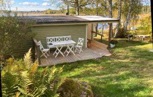a wooden deck with a table and chairs on it at Beautiful Home In Tranås With Lake View in Tranås +12 photos