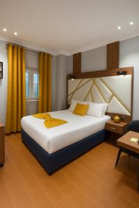 a bedroom with a large bed with yellow curtains at Hôtel Foham Oasis in Bandjoun