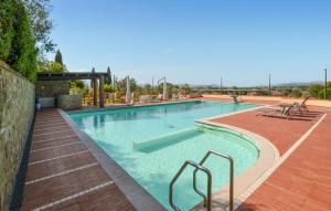 una gran piscina con agua azul y bancos en 3 Bedroom Pet Friendly Home In Arezzo, en Arezzo 35 fotos más
