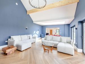 a living room with blue walls and white couches at The Cartlodge - Uk48579 in Rochford