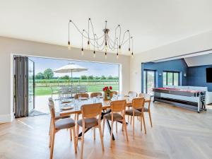 a dining room with a table and chairs and a pool at The Cartlodge - Uk48579 in Rochford