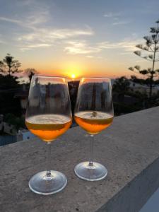 ナルドにあるSalento appartamento con piscinaの夕日を背景にワイン2杯