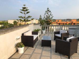 une rangée de chaises et de tables sur un balcon dans l'établissement Salento appartamento con piscina, à Nardò