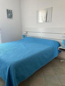 ナルドにあるSalento appartamento con piscinaの青いベッドカバーが備わる白い部屋のベッド1台分です。