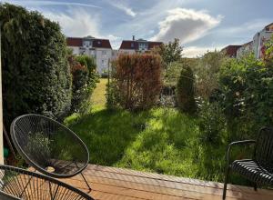 a view of a garden with a chair on a deck at Ankommen & wohlfühlen - Ihr stilvolles Zuhause in Dresden