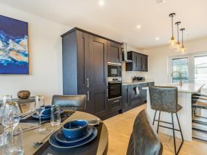 eine Küche und ein Esszimmer mit Tisch und Stühlen in der Unterkunft Bay Tree Cottage - Uk35891 in Ludchurch