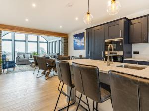 eine offene Küche und ein Wohnzimmer mit einem Tisch und Stühlen in der Unterkunft Bay Tree Cottage - Uk35891 in Ludchurch