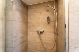 a shower with a shower head in a bathroom at Living Eden by we rent in Zell am See +61 photos