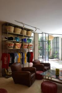 Una habitación con sofás, una mesa y percheros con ropa. en Miostello Lifestyle Riad Marrakech, en Marrakech