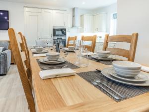 ein Esszimmer mit einem Tisch mit Tellern und Geschirr darauf in der Unterkunft Copper Beech Cottage - Uk35892 in Ludchurch