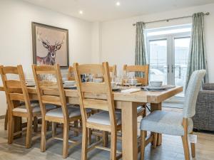 ein Esszimmer mit einem Holztisch und Stühlen in der Unterkunft Copper Beech Cottage - Uk35892 in Ludchurch