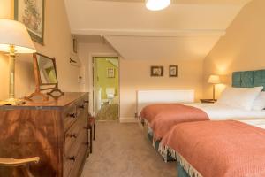 1 dormitorio con 2 camas y vestidor con espejo en Ceseilgwm, en Llangwm