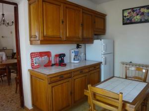 a kitchen with wooden cabinets and a table and a refrigerator at La campagne in Cuers