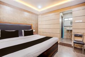 a bedroom with a large bed and a walk in shower at Hotel O Shyama Palace in Jamshedpur