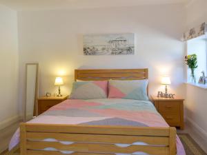 1 dormitorio con 1 cama de madera y 2 mesitas de noche en Parlwr - Uk11210, en Cwrt-newydd