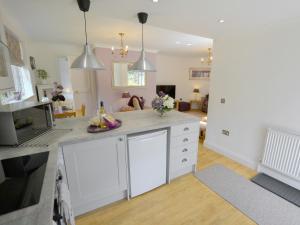Una cocina con gabinetes blancos y una sala de estar. en Alices Lodge, en Ringwood 8 fotos más
