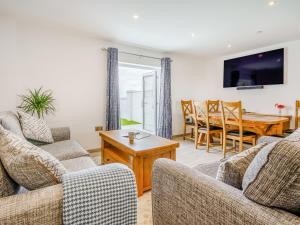 ein Wohnzimmer mit zwei Sofas und einem Tisch in der Unterkunft Willow Tree Cottage - Uk35893 in Ludchurch