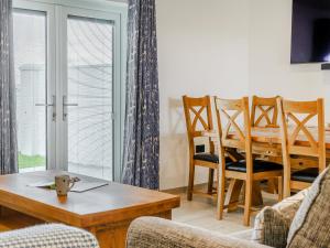 ein Wohnzimmer mit Tisch und Stühlen und ein Esszimmer in der Unterkunft Willow Tree Cottage - Uk35893 in Ludchurch