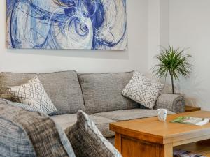 ein Wohnzimmer mit Sofa und Tisch in der Unterkunft Willow Tree Cottage - Uk35893 in Ludchurch