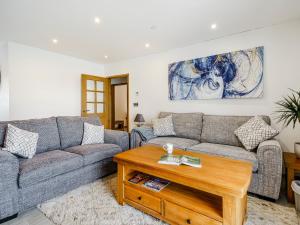 ein Wohnzimmer mit einer Couch und einem Couchtisch in der Unterkunft Willow Tree Cottage - Uk35893 in Ludchurch