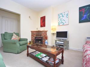 a living room with a coffee table and a fireplace at Pepper Pot Cottage in Compton