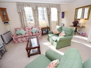 a living room with two couches and a tv at Pepper Pot Cottage in Compton